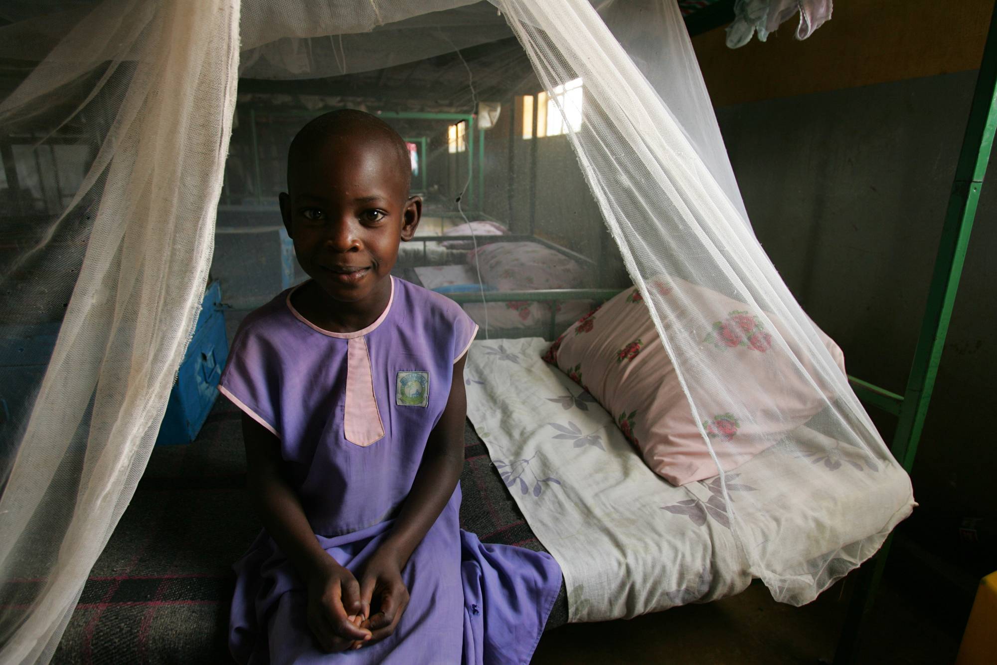 a-child-sits-under-a-malaria-net_2000x1333